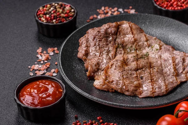 Izgara biftek, barbeküde tuzlu ve biberli et. Yemek arkaplanı olarak ızgara biftek.