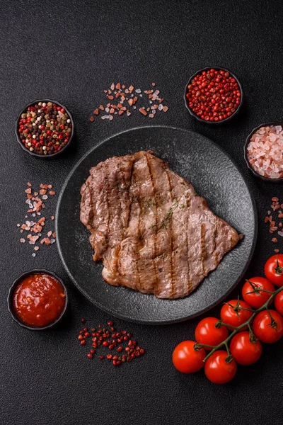 Izgara biftek, barbeküde tuzlu ve biberli et. Yemek arkaplanı olarak ızgara biftek.