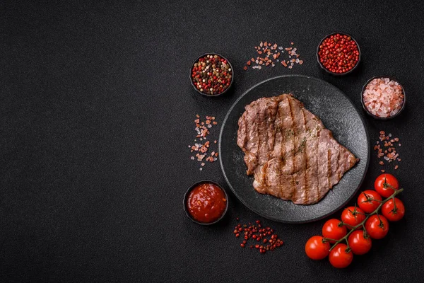 Izgara biftek, barbeküde tuzlu ve biberli et. Yemek arkaplanı olarak ızgara biftek.