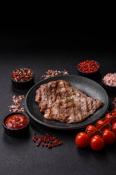 Izgara biftek, barbeküde tuzlu ve biberli et. Yemek arkaplanı olarak ızgara biftek.
