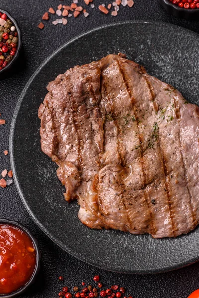Izgara biftek, barbeküde tuzlu ve biberli et. Yemek arkaplanı olarak ızgara biftek.