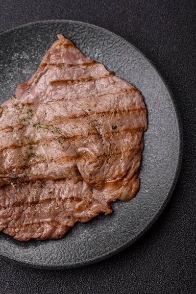 Izgara biftek, barbeküde tuzlu ve biberli et. Yemek arkaplanı olarak ızgara biftek.