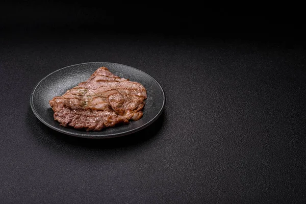 Izgara biftek, barbeküde tuzlu ve biberli et. Yemek arkaplanı olarak ızgara biftek.