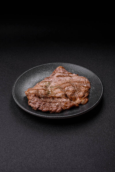 Grilled beef steak, meat cooked on barbecue with salt and pepper. Grilled beef steak as food background