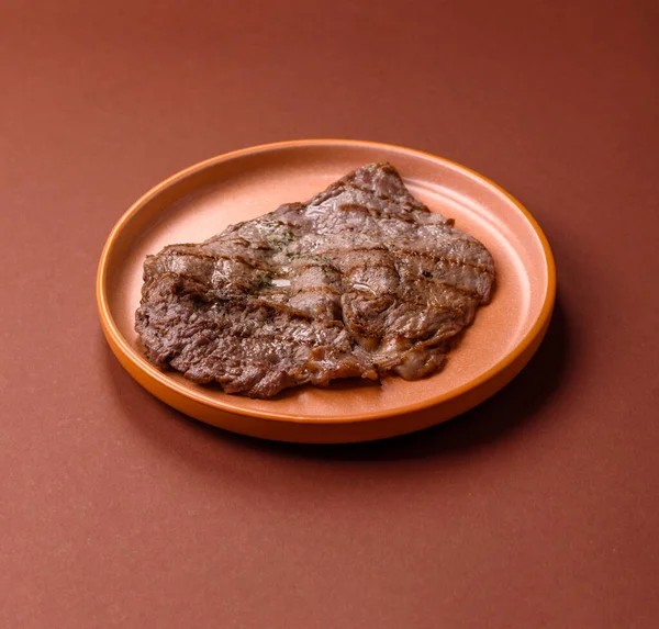 Izgara biftek, barbeküde tuzlu ve biberli et. Yemek arkaplanı olarak ızgara biftek.