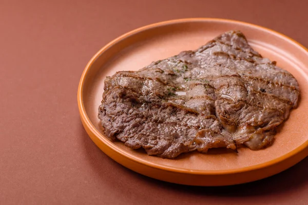 Izgara biftek, barbeküde tuzlu ve biberli et. Yemek arkaplanı olarak ızgara biftek.