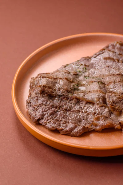 Izgara biftek, barbeküde tuzlu ve biberli et. Yemek arkaplanı olarak ızgara biftek.