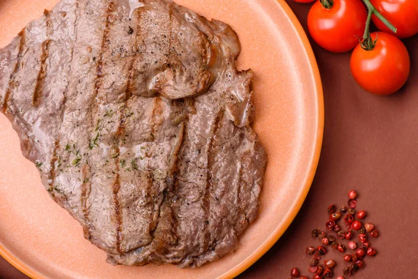 Izgara biftek, barbeküde tuzlu ve biberli et. Yemek arkaplanı olarak ızgara biftek.