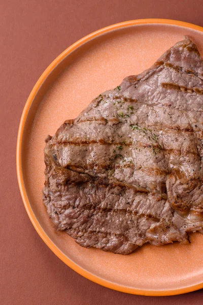 Izgara biftek, barbeküde tuzlu ve biberli et. Yemek arkaplanı olarak ızgara biftek.