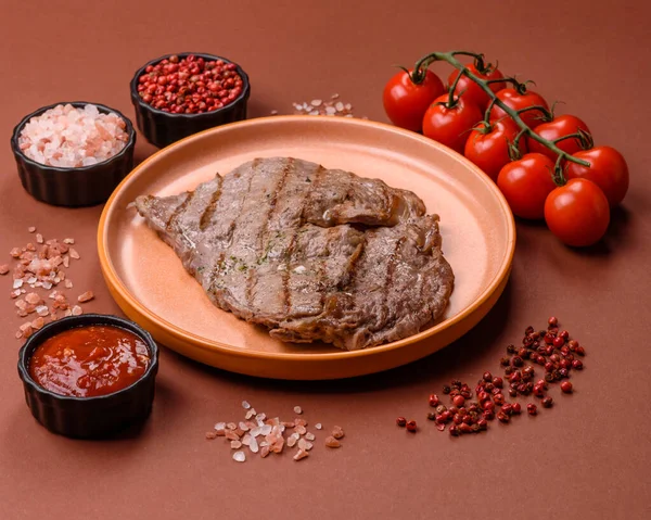 Izgara biftek, barbeküde tuzlu ve biberli et. Yemek arkaplanı olarak ızgara biftek.