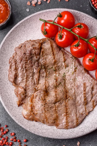 Izgara biftek, barbeküde tuzlu ve biberli et. Yemek arkaplanı olarak ızgara biftek.