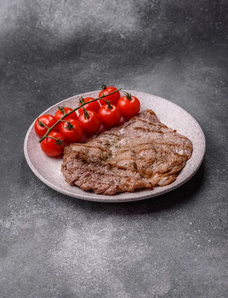 Izgara biftek, barbeküde tuzlu ve biberli et. Yemek arkaplanı olarak ızgara biftek.