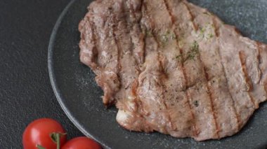 Izgara biftek, barbeküde tuzlu ve biberli et. Yemek arkaplanı olarak ızgara biftek.
