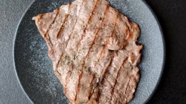 Izgara biftek, barbeküde tuzlu ve biberli et. Yemek arkaplanı olarak ızgara biftek.