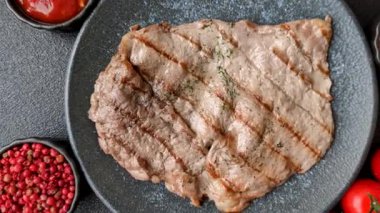 Izgara biftek, barbeküde tuzlu ve biberli et. Yemek arkaplanı olarak ızgara biftek.