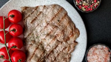 Izgara biftek, barbeküde tuzlu ve biberli et. Yemek arkaplanı olarak ızgara biftek.