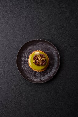 Fıstıklı kek ya da üzeri fındıklı yeşil krema ve meyve dolgulu turta. Tasarımınız için yemek arkaplanı olarak fıstıklı turta