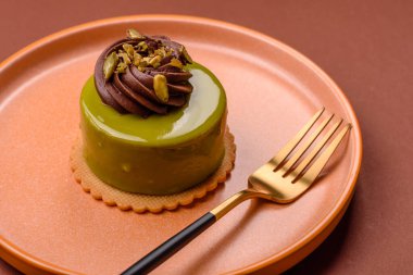 Fıstıklı kek ya da üzeri fındıklı yeşil krema ve meyve dolgulu turta. Tasarımınız için yemek arkaplanı olarak fıstıklı turta