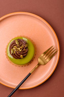 Fıstıklı kek ya da üzeri fındıklı yeşil krema ve meyve dolgulu turta. Tasarımınız için yemek arkaplanı olarak fıstıklı turta