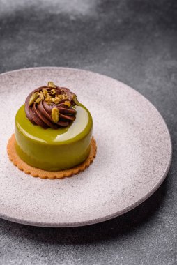 Fıstıklı kek ya da üzeri fındıklı yeşil krema ve meyve dolgulu turta. Tasarımınız için yemek arkaplanı olarak fıstıklı turta