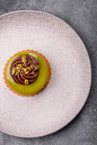 Fıstıklı kek ya da üzeri fındıklı yeşil krema ve meyve dolgulu turta. Tasarımınız için yemek arkaplanı olarak fıstıklı turta