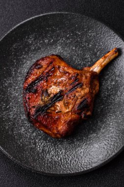 Biftek, biftek ya da kemiğe domuz eti, ızgarada et, biberiye, tuz ve baharatla pişirilmiş. Tasarımın için yemek arkaplanı olarak kemiğe biftek.