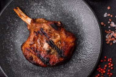 Biftek, biftek ya da kemiğe domuz eti, ızgarada et, biberiye, tuz ve baharatla pişirilmiş. Tasarımın için yemek arkaplanı olarak kemiğe biftek.