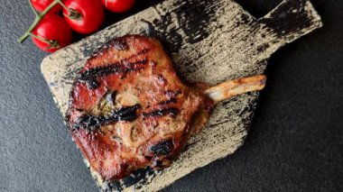 Biftek, biftek ya da kemiğe domuz eti, ızgarada et, biberiye, tuz ve baharatla pişirilmiş. Tasarımın için yemek arkaplanı olarak kemiğe biftek.