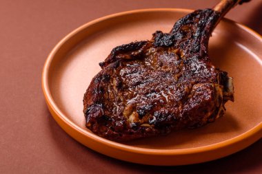 Kızarmış kemik eti, dana baltası bifteği, sulu ızgara et. Tomahawk bifteği tasarımın için yemek arka planı olarak kullanılacak..