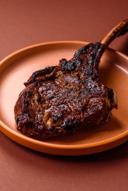Kızarmış kemik eti, dana baltası bifteği, sulu ızgara et. Tomahawk bifteği tasarımın için yemek arka planı olarak kullanılacak..