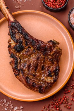Kızarmış kemik eti, dana baltası bifteği, sulu ızgara et. Tomahawk bifteği tasarımın için yemek arka planı olarak kullanılacak..