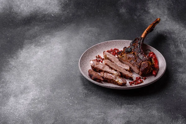 Kızarmış kemik eti, dana baltası bifteği, sulu ızgara et. Tomahawk bifteği tasarımın için yemek arka planı olarak kullanılacak..