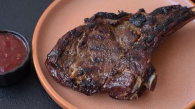 Kızarmış kemik eti, dana baltası bifteği, sulu ızgara et. Tomahawk bifteği tasarımın için yemek arka planı olarak kullanılacak..