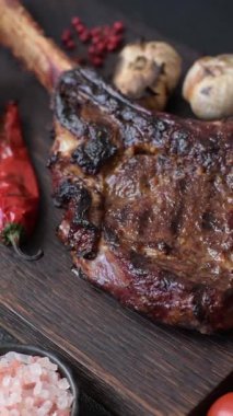 Kızarmış kemik eti, dana baltası bifteği, sulu ızgara et. Tomahawk bifteği tasarımın için yemek arka planı olarak kullanılacak..