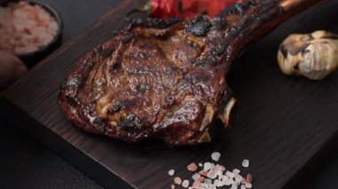 Kızarmış kemik eti, dana baltası bifteği, sulu ızgara et. Tomahawk bifteği tasarımın için yemek arka planı olarak kullanılacak..