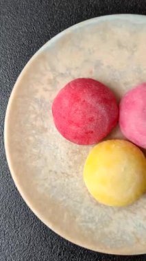 Japon mochi, dondurma ya da meyveli pirinç unundan yapılmış Asya tatlısı. Farklı renklerde mochi ve yiyecek arka planı olarak meyve dolgu