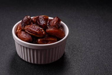 Seramik tabakta kurutulmuş hurmalar, ramazan tabağı için Arapça yiyecekler. Kurumuş tarihler tasarımın için bir yemek arkaplanı olarak kullanılacak..