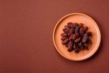 Seramik tabakta kurutulmuş hurmalar, ramazan tabağı için Arapça yiyecekler. Kurumuş tarihler tasarımın için bir yemek arkaplanı olarak kullanılacak..