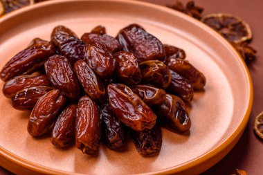 Seramik tabakta kurutulmuş hurmalar, ramazan tabağı için Arapça yiyecekler. Kurumuş tarihler tasarımın için bir yemek arkaplanı olarak kullanılacak..