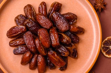 Seramik tabakta kurutulmuş hurmalar, ramazan tabağı için Arapça yiyecekler. Kurumuş tarihler tasarımın için bir yemek arkaplanı olarak kullanılacak..