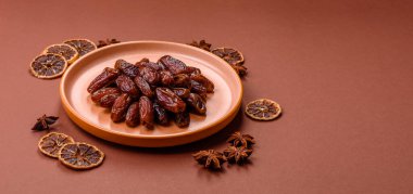 Seramik tabakta kurutulmuş hurmalar, ramazan tabağı için Arapça yiyecekler. Kurumuş tarihler tasarımın için bir yemek arkaplanı olarak kullanılacak..