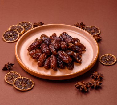 Seramik tabakta kurutulmuş hurmalar, ramazan tabağı için Arapça yiyecekler. Kurumuş tarihler tasarımın için bir yemek arkaplanı olarak kullanılacak..