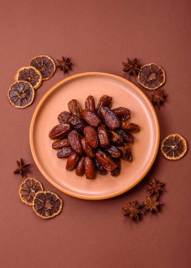 Seramik tabakta kurutulmuş hurmalar, ramazan tabağı için Arapça yiyecekler. Kurumuş tarihler tasarımın için bir yemek arkaplanı olarak kullanılacak..