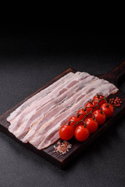 Raw or smoked pork bacon slices or strips as a breakfast ingredient. Raw bacon as a food background for your design.