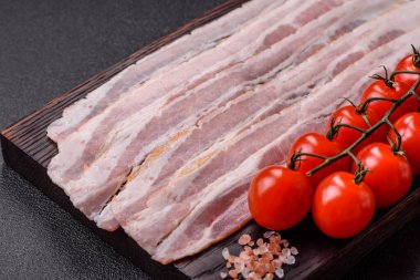 Raw or smoked pork bacon slices or strips as a breakfast ingredient. Raw bacon as a food background for your design.