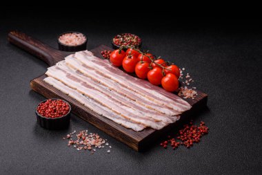 Raw or smoked pork bacon slices or strips as a breakfast ingredient. Raw bacon as a food background for your design.