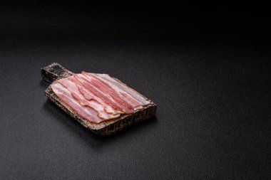 Raw or smoked pork bacon slices or strips as a breakfast ingredient. Raw bacon as a food background for your design.