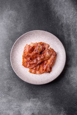 Fried pork bacon slices or strips as a breakfast ingredient. Fried bacon as a food background for your design