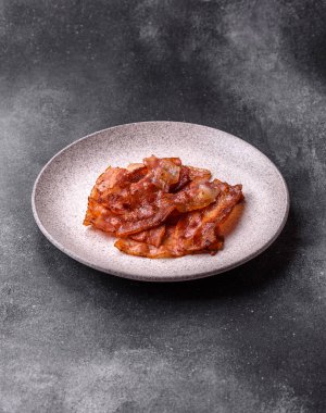 Fried pork bacon slices or strips as a breakfast ingredient. Fried bacon as a food background for your design