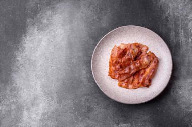 Fried pork bacon slices or strips as a breakfast ingredient. Fried bacon as a food background for your design